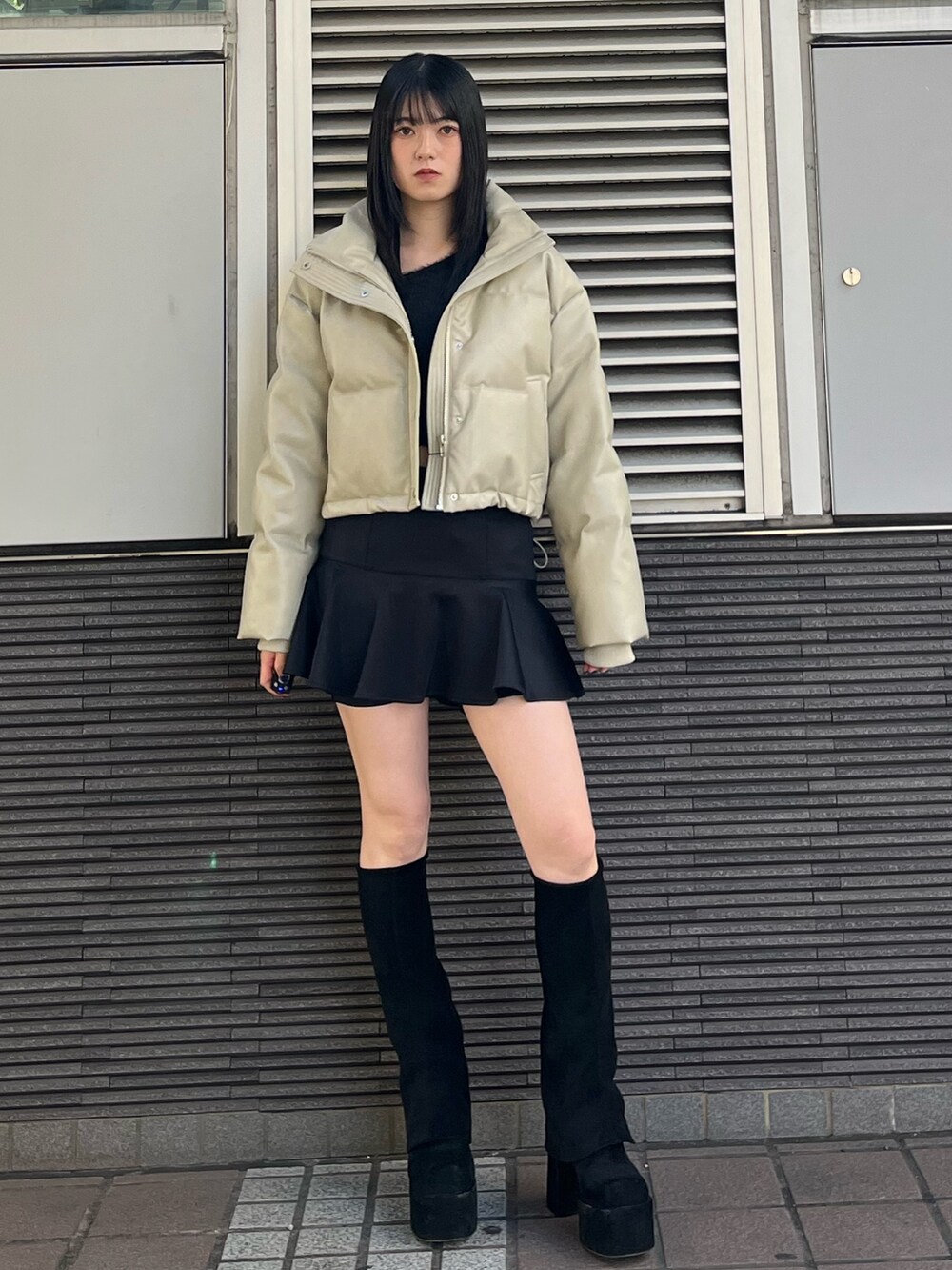 ブラック系のスカート、ブラック系のブーツ、ブラック系のニット/セーターを着用したレディースの冬コーディネートの2枚目の写真