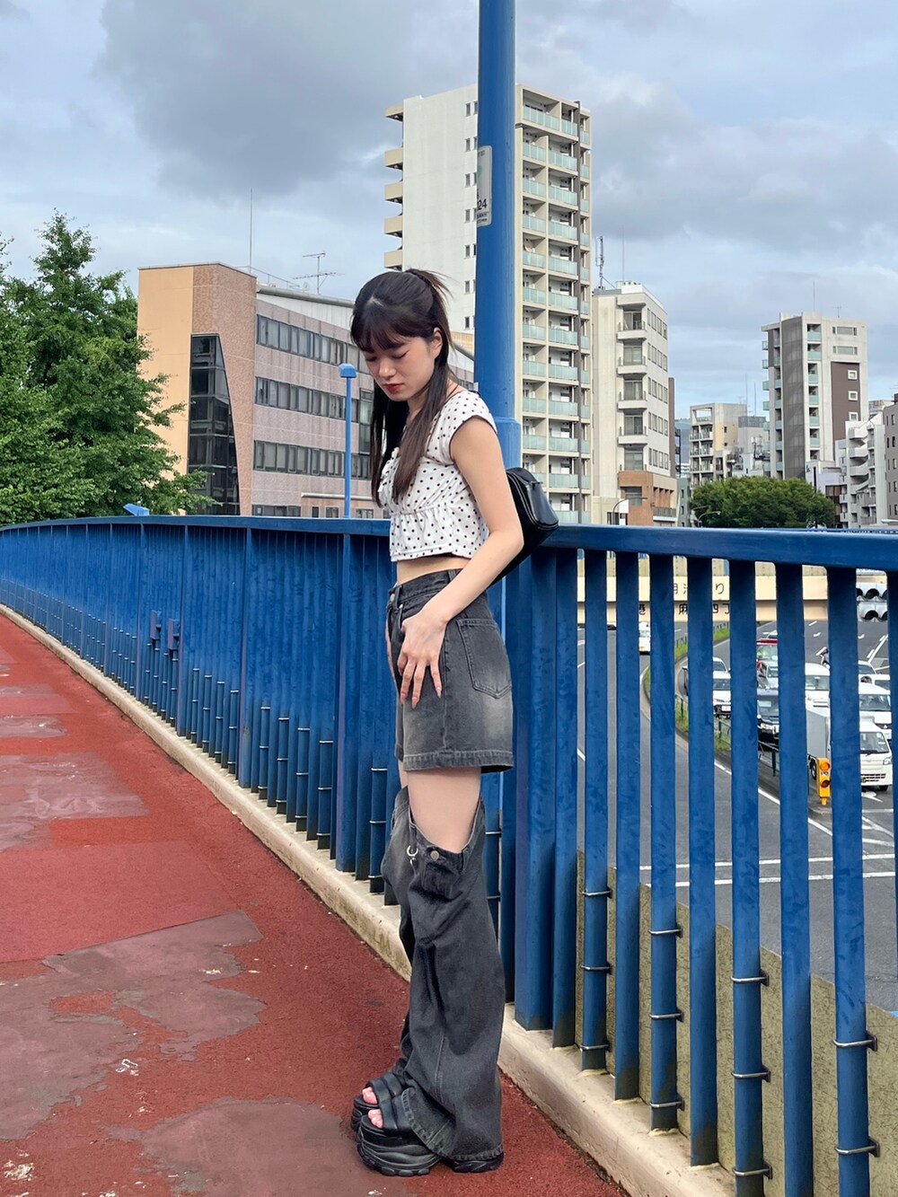 ホワイト系のタンクトップ、ブラック系のデニムパンツ、ブラック系のサンダルを着用したレディースの夏コーディネートの3枚目の写真