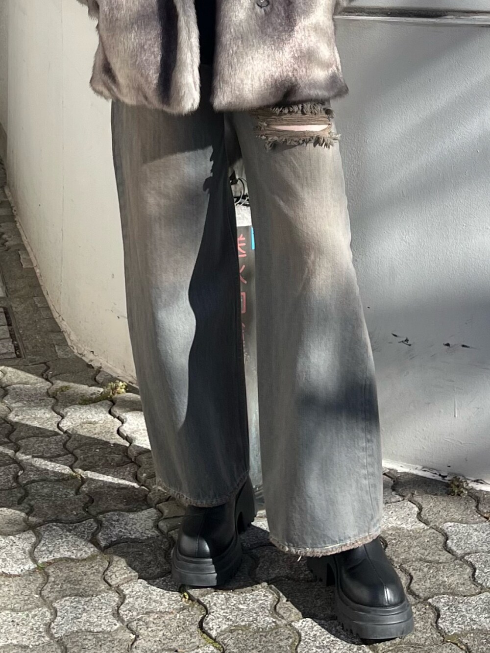グレー系のその他アウター、グレー系のデニムパンツ、ブラック系のニット/セーターを着用したレディースの冬コーディネートの7枚目の写真
