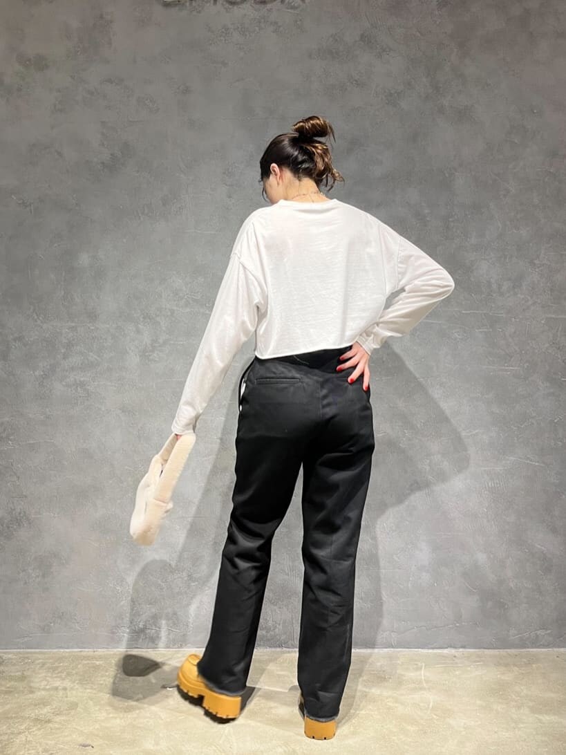 ホワイト系のハンドバッグ、ホワイト系のTシャツ/カットソー、ブラウン系のブーツを着用したレディースの秋コーディネートの4枚目の写真