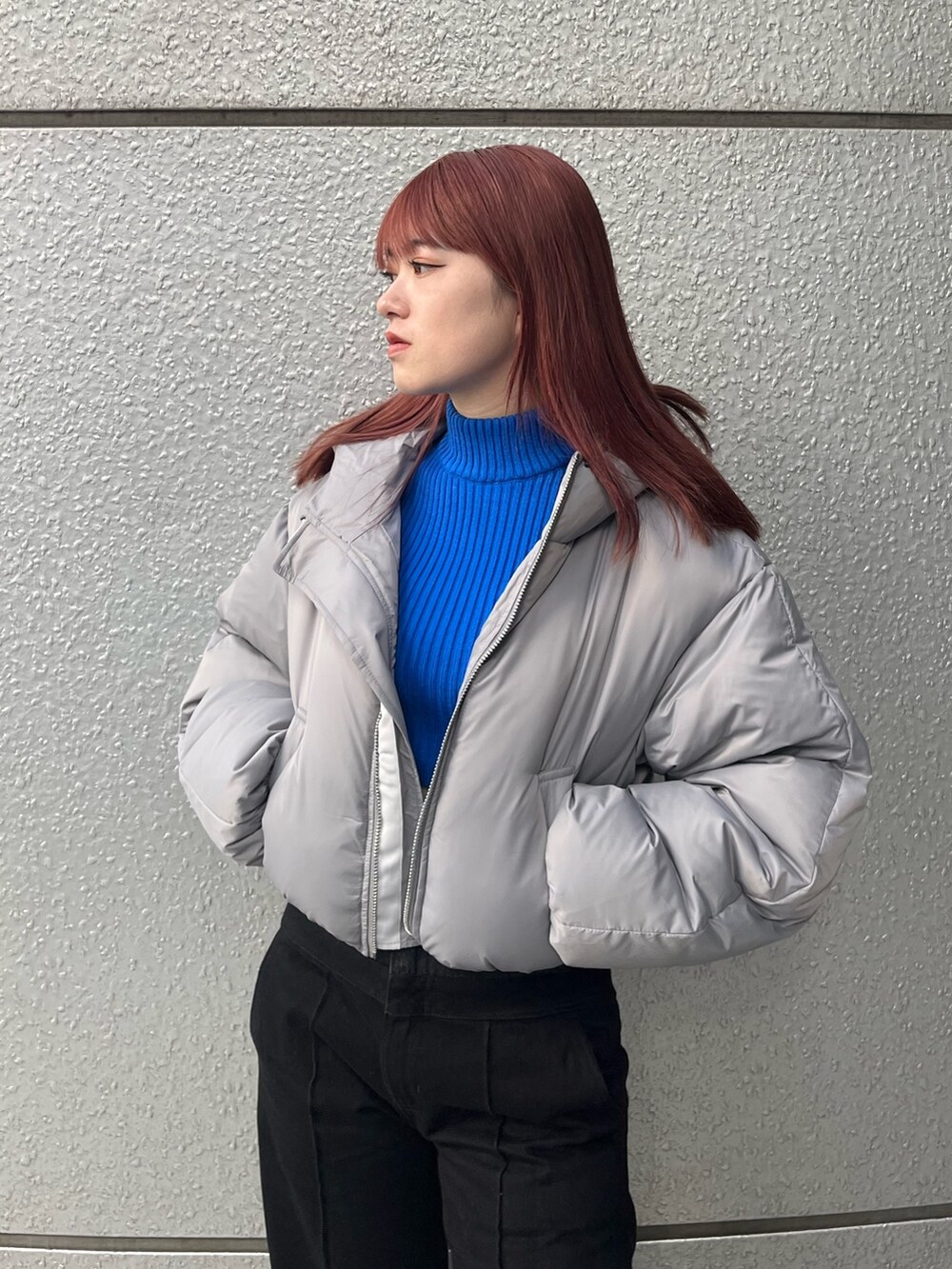 ブラック系のデニムパンツ、ブルー系のニット/セーター、グレー系のダウンジャケット/コートを着用したレディースの冬コーディネートの5枚目の写真