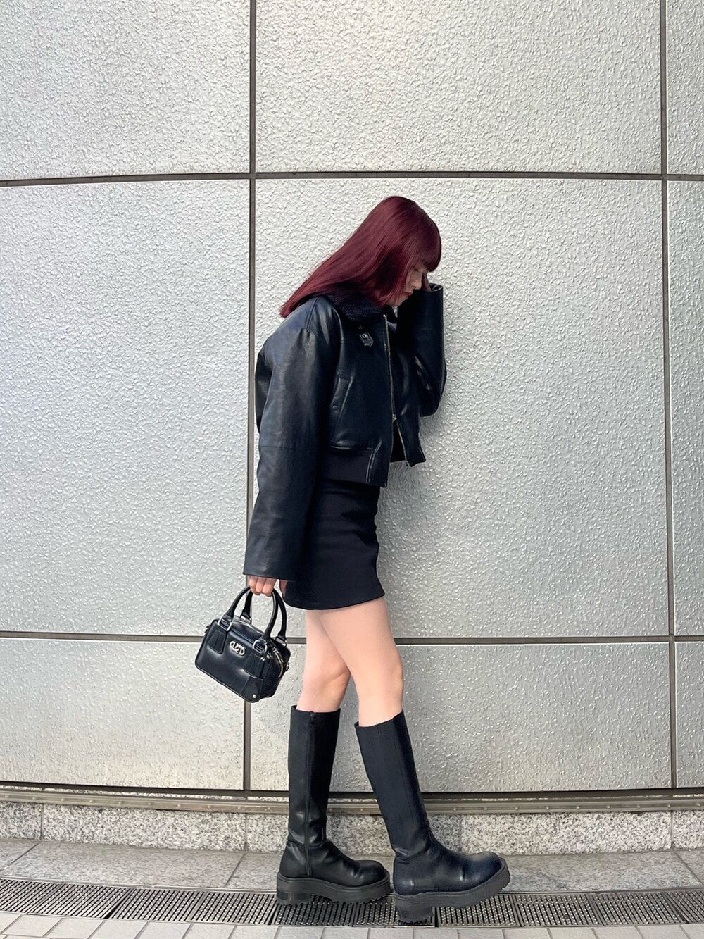 ブラック系のスカート、ブラック系のブルゾン、グレー系のニット/セーターを着用したレディースの冬コーディネートの3枚目の写真