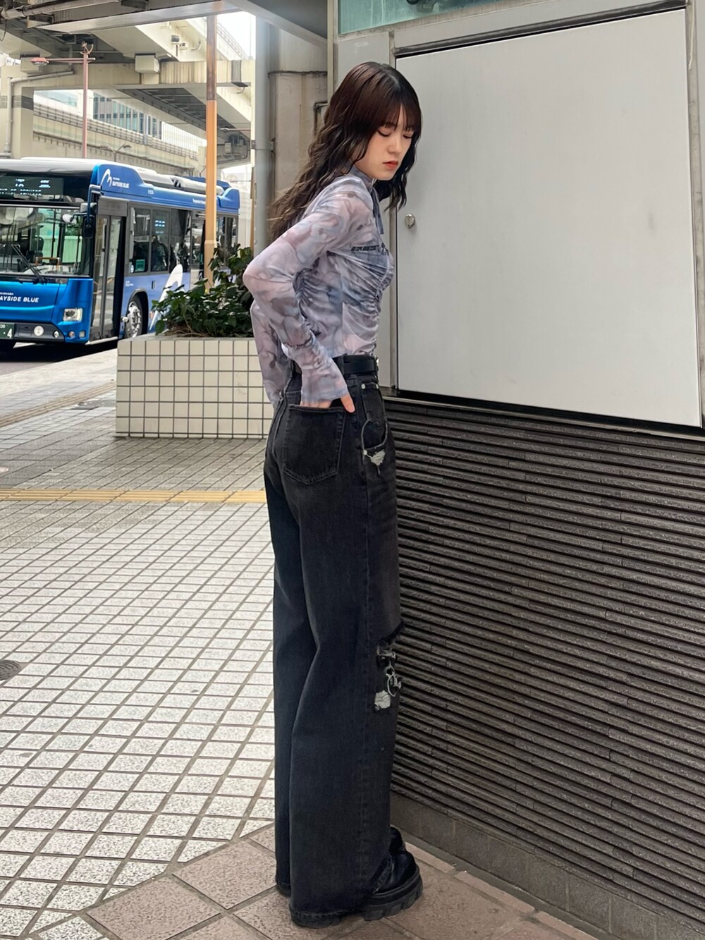 ブラック系のデニムパンツ、ブルー系のTシャツ/カットソー、ブラック系のブーツを着用したレディースの春コーディネートの3枚目の写真