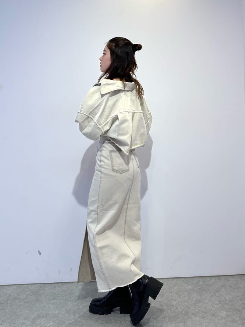 ホワイト系のデニムジャケット、ホワイト系のスカート、ブラック系のブーツを着用したレディースの夏コーディネートの4枚目の写真