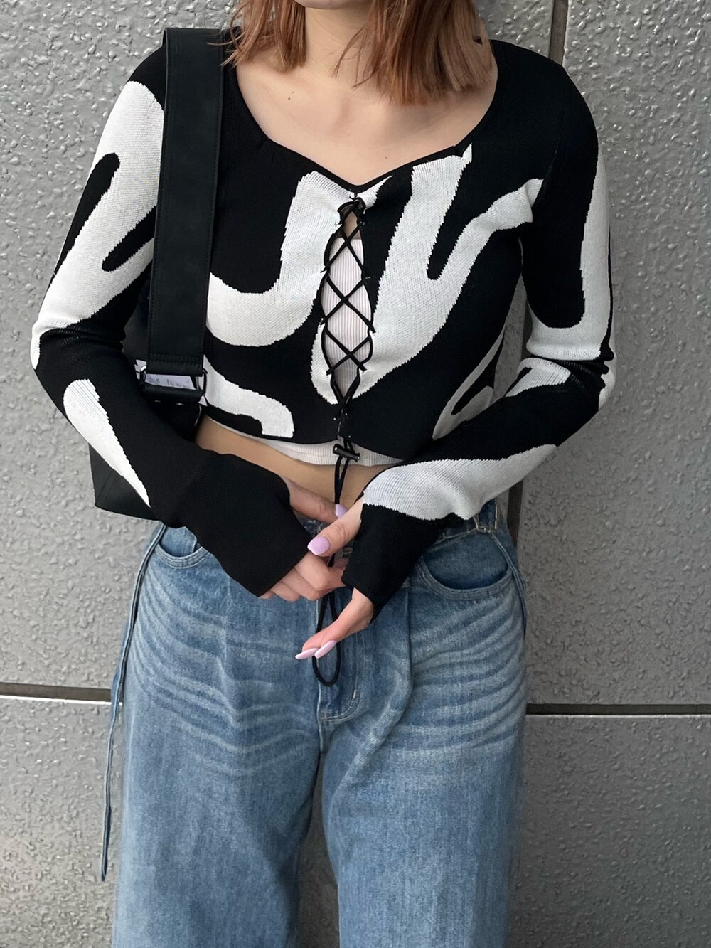 ブラック系のスニーカー、ブルー系のデニムパンツ、ホワイト系のキャミソールを着用したレディースの冬コーディネートの7枚目の写真