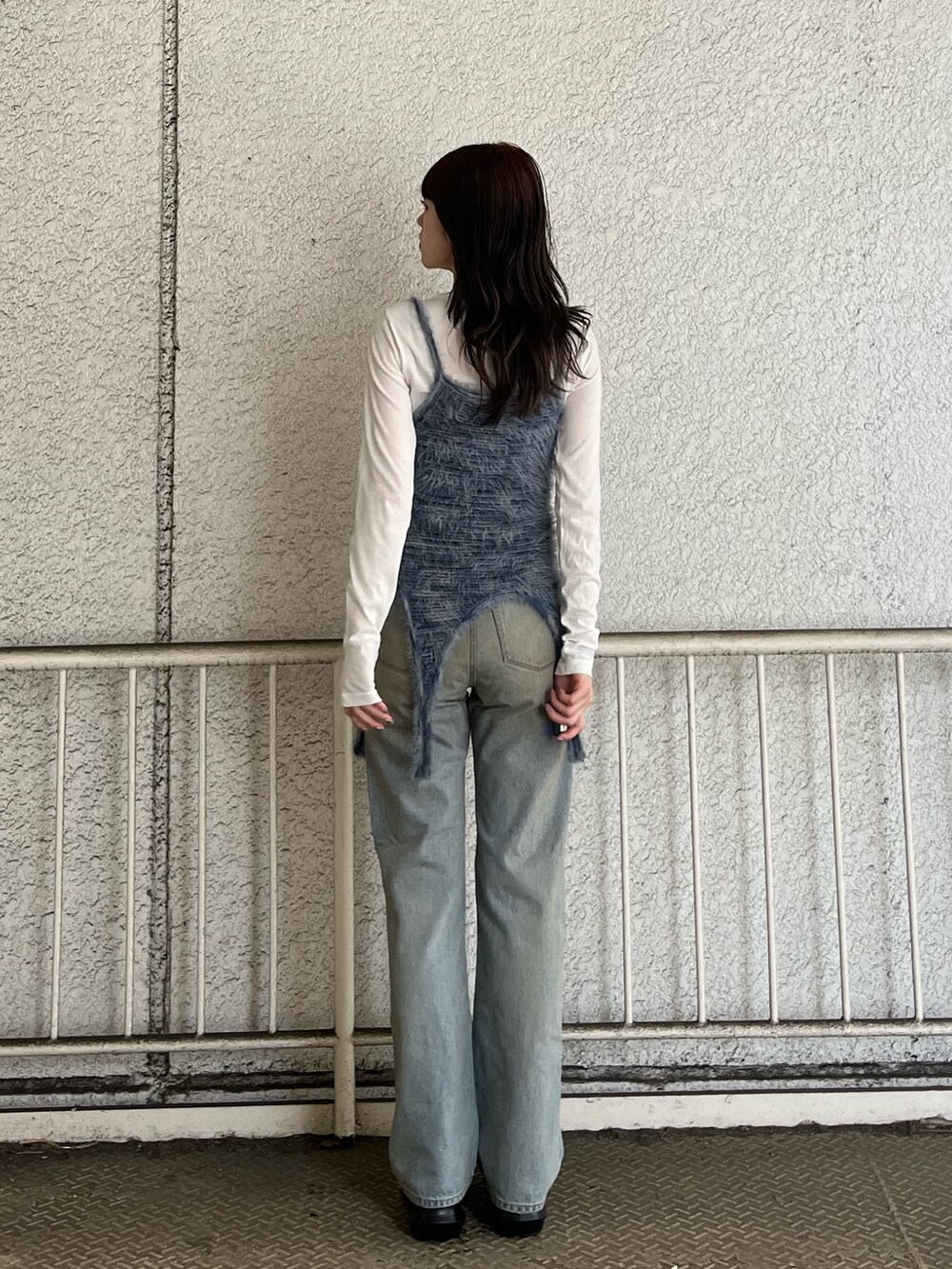 ブルー系のニット/セーター、ホワイト系のTシャツ/カットソー、ブルー系のデニムパンツを着用したレディースの春コーディネートの3枚目の写真