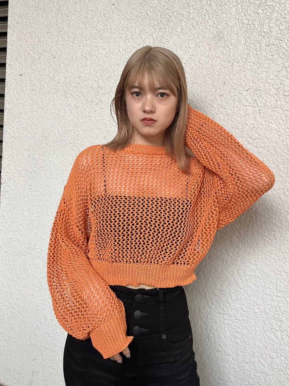 ブラック系のキャミソール、オレンジ系のニット/セーター、ブラック系のサンダルを着用したレディースの春コーディネートの4枚目の写真