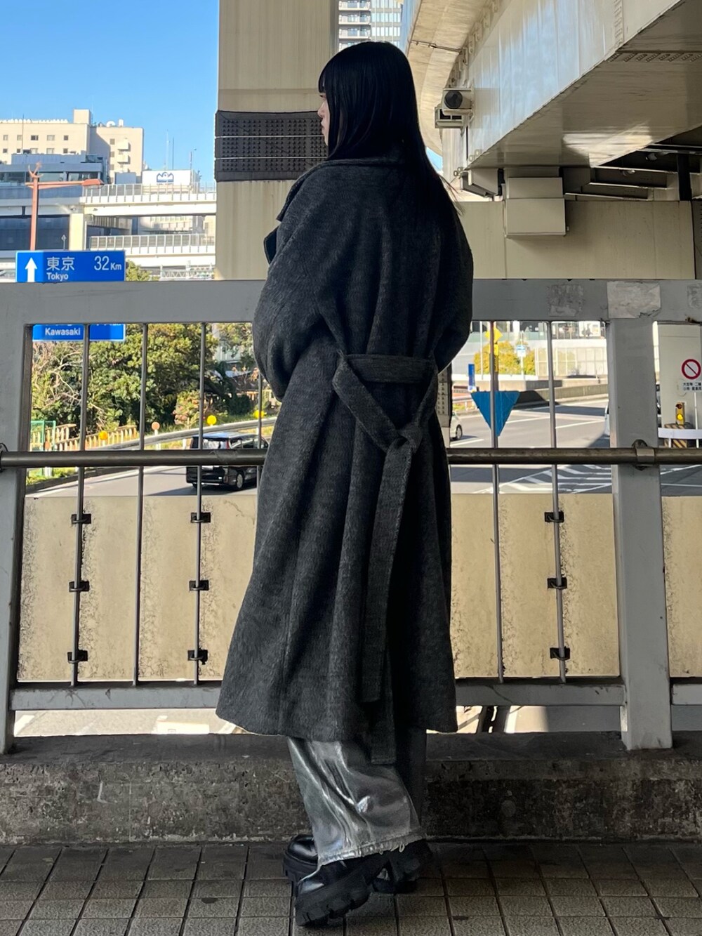 ブラック系のブーツ、ブラック系のニット/セーター、ブルー系のデニムパンツを着用したレディースの冬コーディネートの3枚目の写真