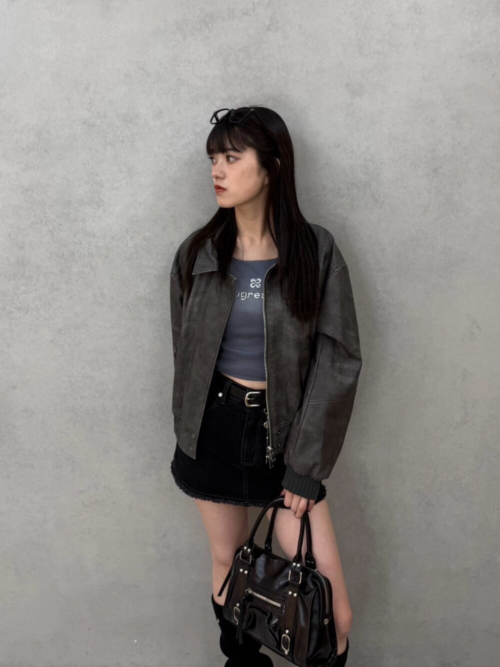 ブラック系のスカート、グレー系のTシャツ/カットソー、グレー系のブルゾンを着用したレディースの秋コーディネートの3枚目の写真