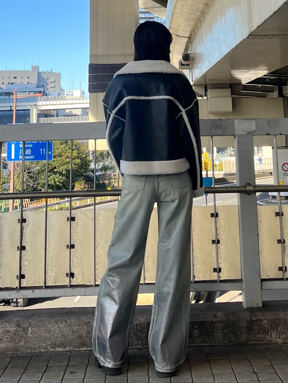 ブルー系のデニムパンツ、ブラック系のニット/セーター、ブラック系のブーツを着用したレディースの冬コーディネートの4枚目の写真