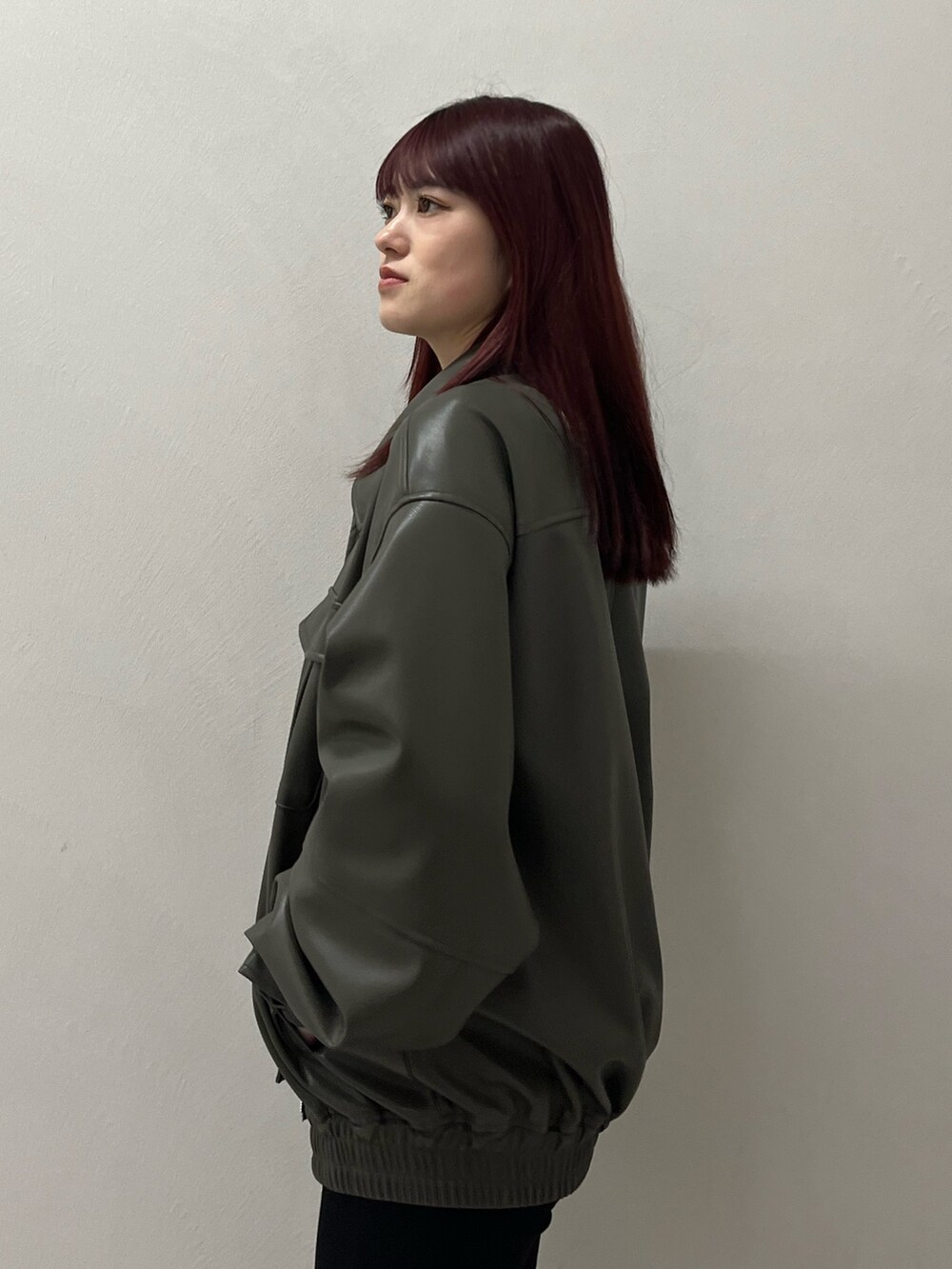 グレー系のブルゾン、ブラック系のデニムパンツ、ブラック系のニット/セーターを着用したレディースの冬コーディネートの6枚目の写真