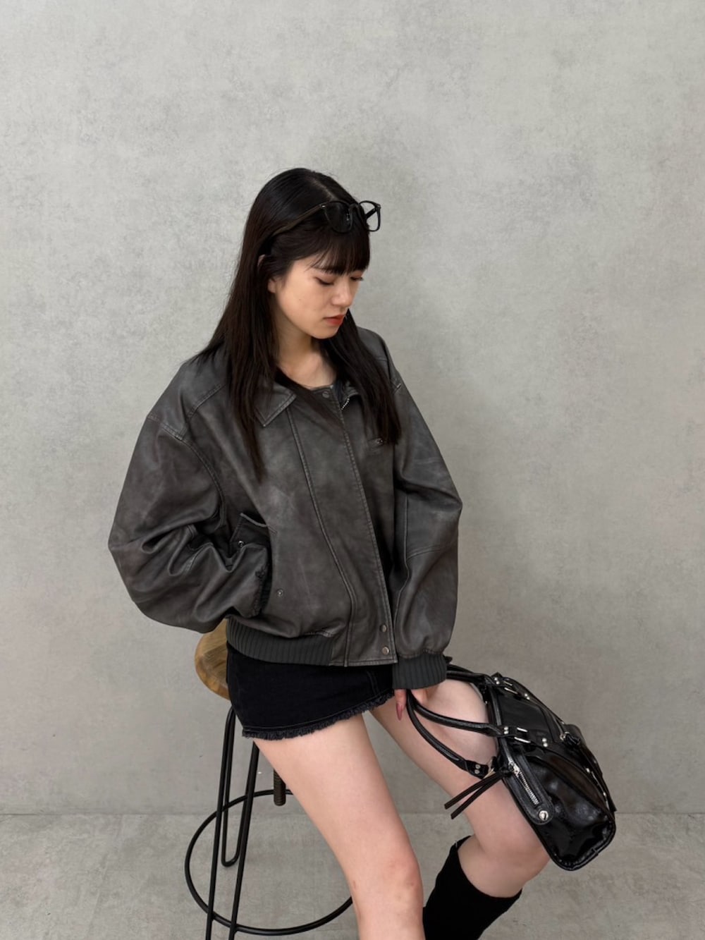 ブラック系のスカート、グレー系のTシャツ/カットソー、グレー系のブルゾンを着用したレディースの秋コーディネートの4枚目の写真