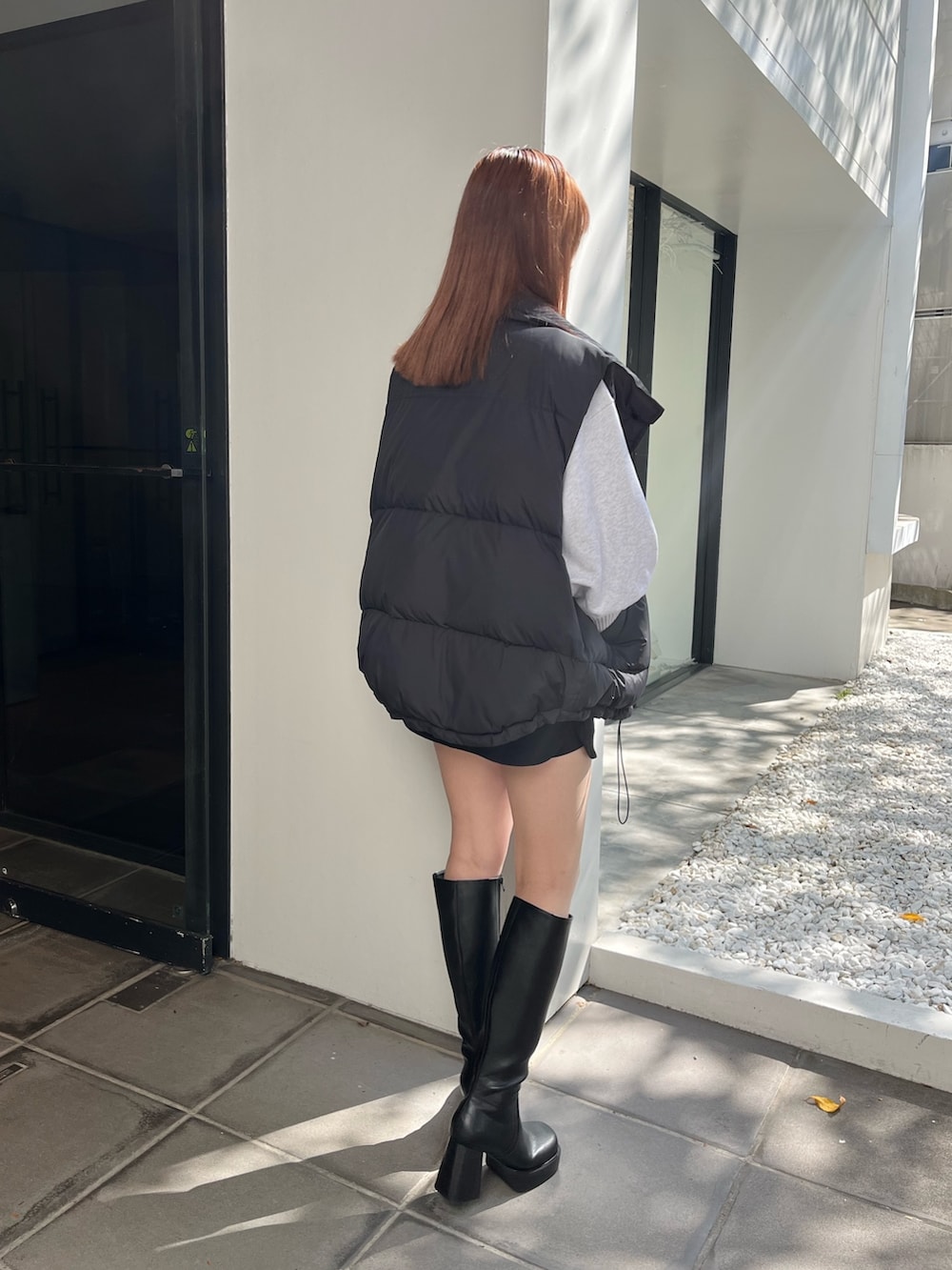 ブラック系のブーツ、グレー系のスウェット、ブラック系のスカートを着用したレディースの秋コーディネートの4枚目の写真