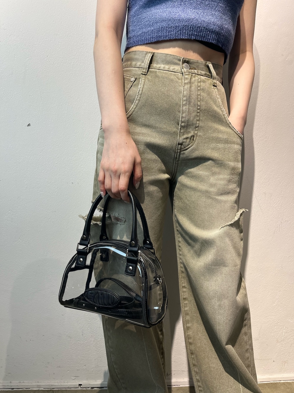 ベージュ系のデニムパンツ、その他のハンドバッグ、ブルー系のタンクトップを着用したレディースの春コーディネートの8枚目の写真