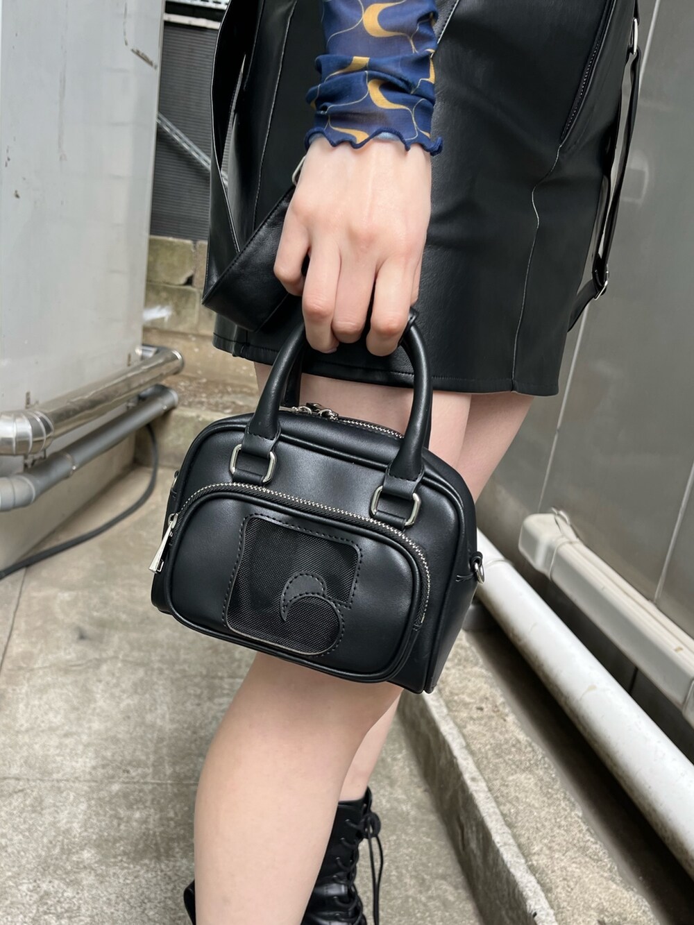 ブラック系のブーツ、ブラック系のスカート、その他のTシャツ/カットソーを着用したレディースの冬コーディネートの6枚目の写真