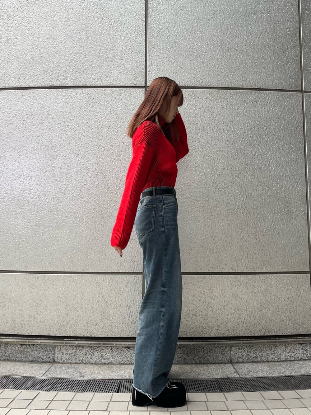 ブラック系のブーツ、ブルー系のデニムパンツ、レッド系のニット/セーターを着用したレディースの秋コーディネートの5枚目の写真