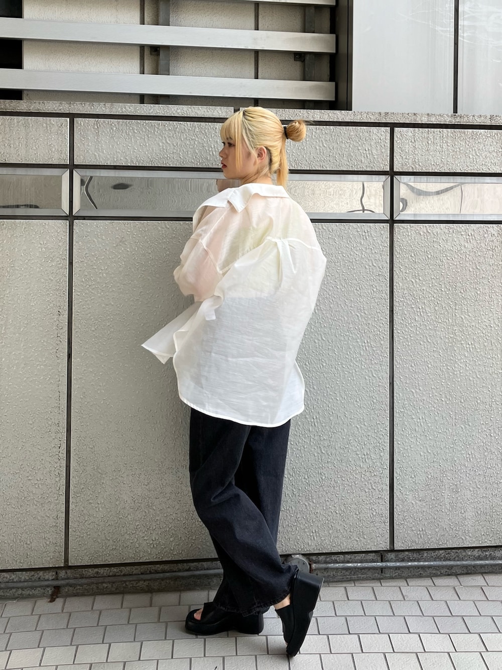 ブラック系のデニムパンツ、ブラック系のサンダル、イエロー系のタンクトップを着用したレディースの春コーディネートの3枚目の写真