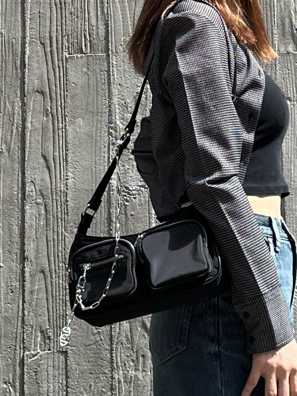 ブラック系のブーツ、ブラック系のキャミソール、ブルー系のデニムパンツを着用したレディースの夏コーディネートの7枚目の写真