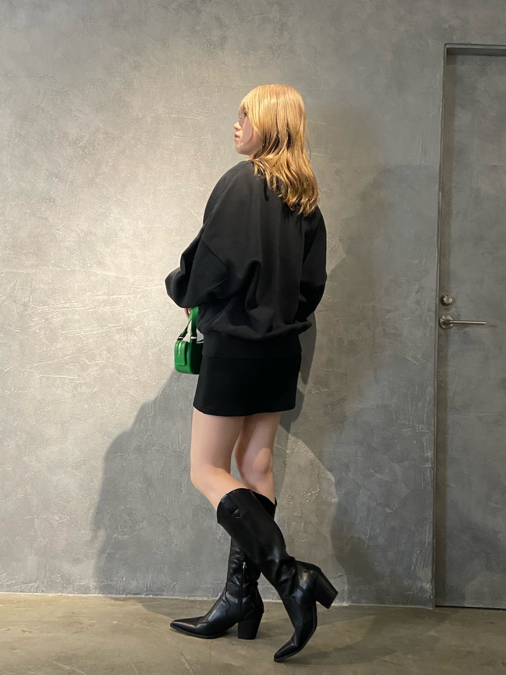 ブラック系のTシャツ/カットソー、ブラック系のブーツ、ブラック系のスカートを着用したレディースの冬コーディネートの3枚目の写真
