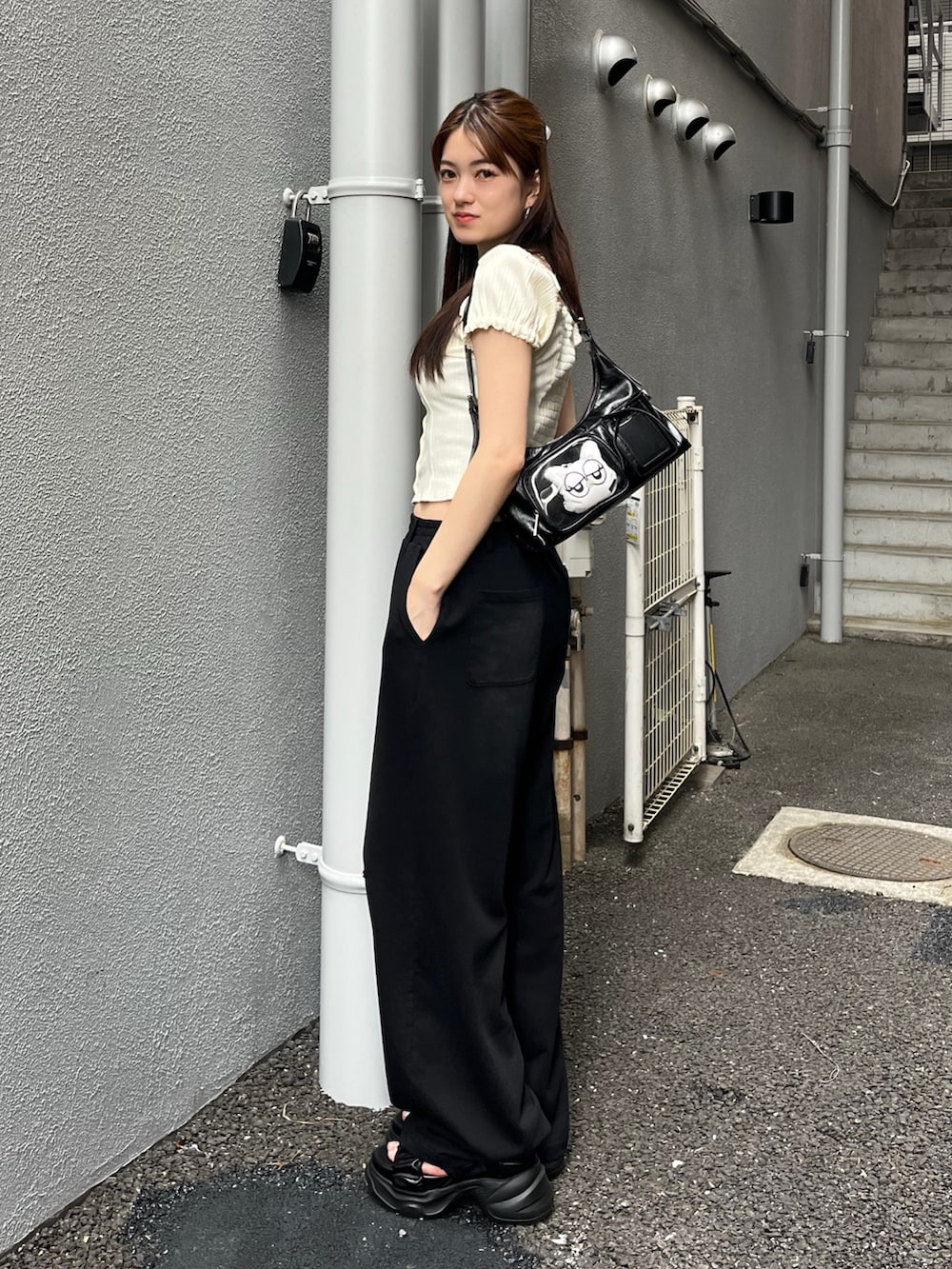ホワイト系のTシャツ/カットソー、ブラック系のスウェットパンツ、ブラック系のハンドバッグを着用したレディースの夏コーディネートの2枚目の写真