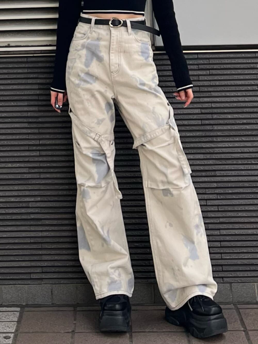 ブラック系のスニーカー、ホワイト系のデニムパンツ、ブラック系のニット/セーターを着用したレディースの冬コーディネートの7枚目の写真