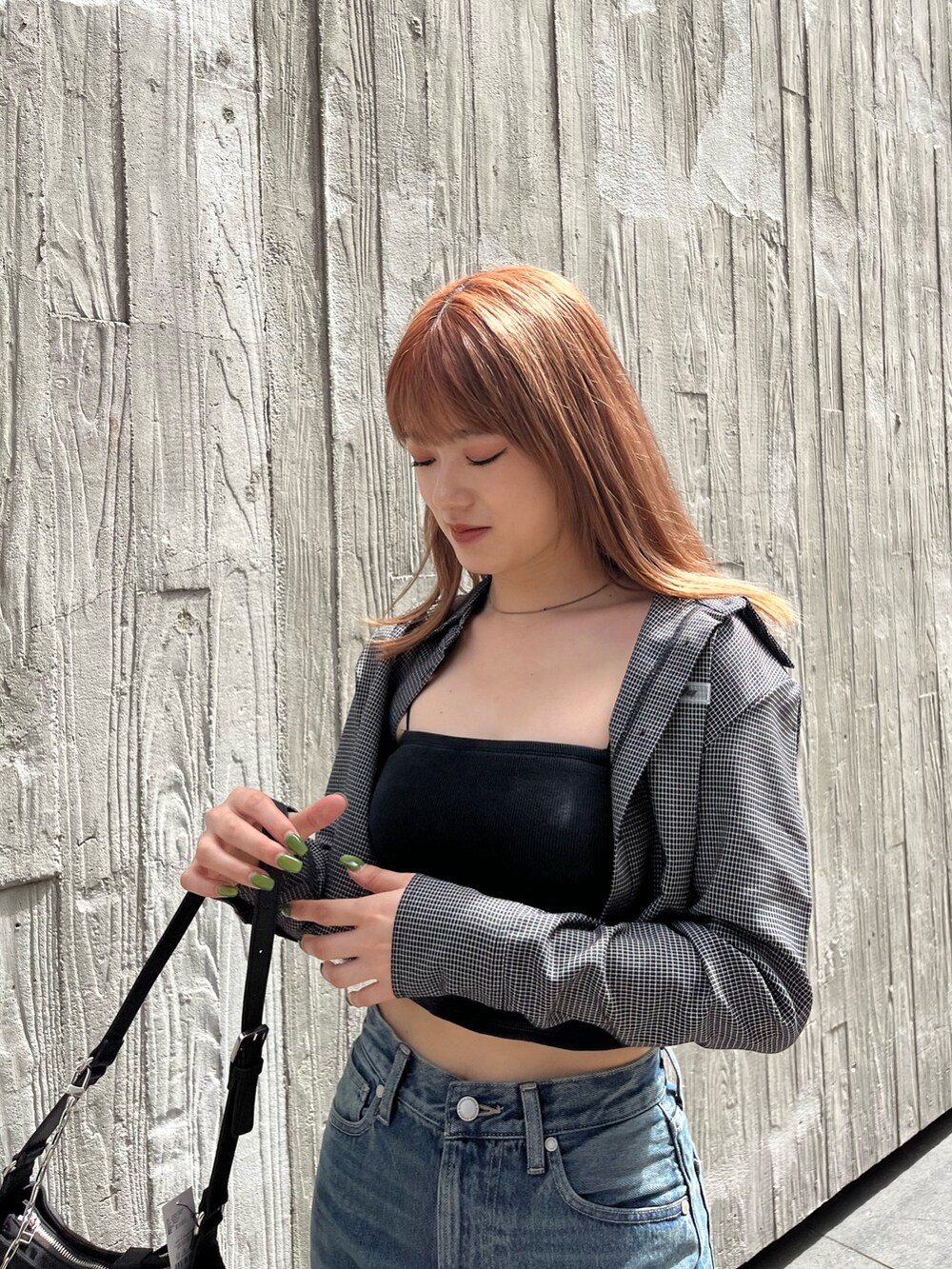 ブラック系のブーツ、ブラック系のキャミソール、ブルー系のデニムパンツを着用したレディースの夏コーディネートの4枚目の写真