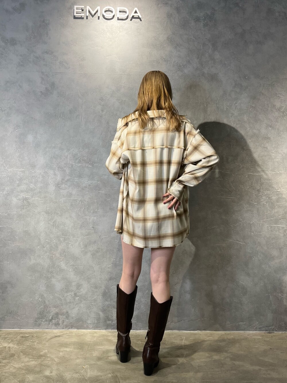 ブラック系のスカート、ベージュ系のシャツ/ブラウス、ブラウン系のブーツを着用したレディースの冬コーディネートの3枚目の写真