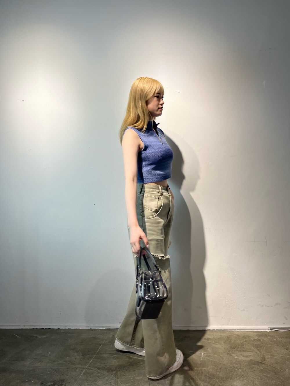 ベージュ系のデニムパンツ、その他のハンドバッグ、ブルー系のタンクトップを着用したレディースの春コーディネートの5枚目の写真