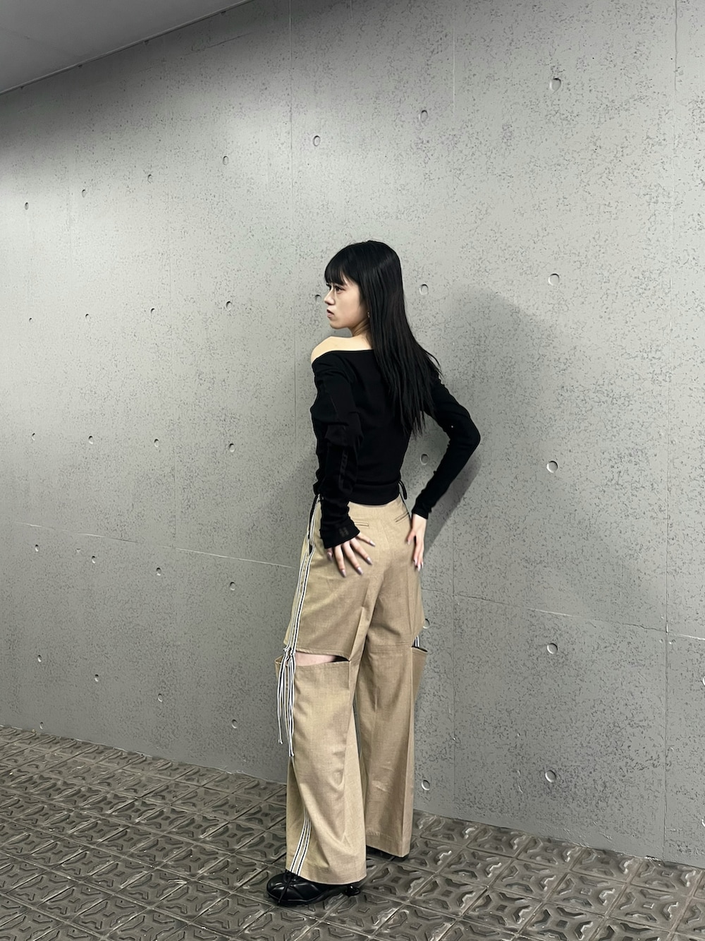 ベージュ系のその他パンツ、ブラック系のTシャツ/カットソー、ブラック系のスニーカーを着用したレディースの冬コーディネートの2枚目の写真