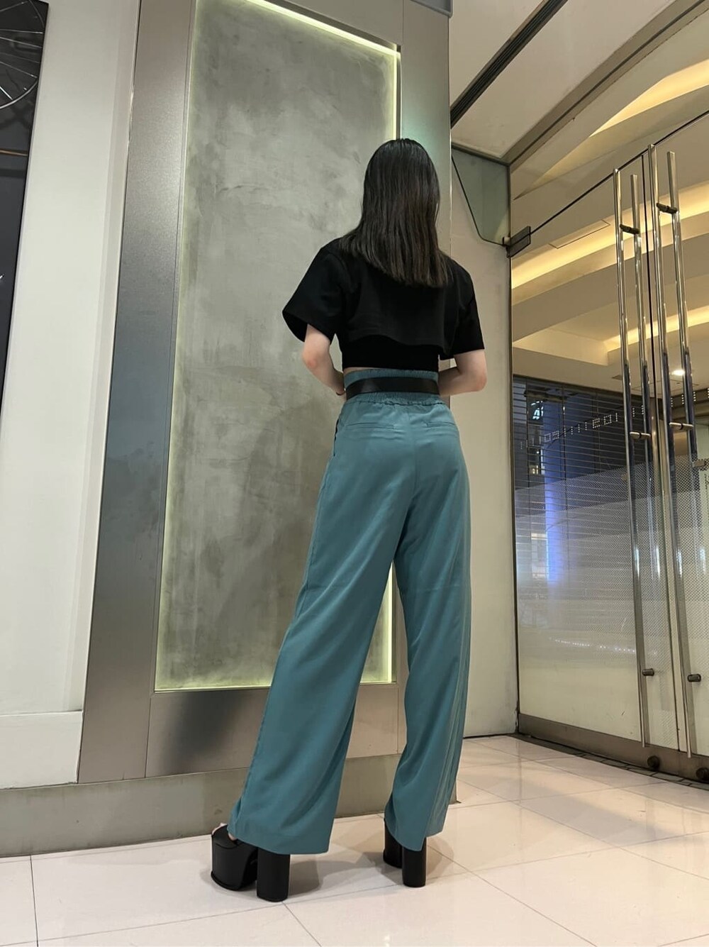 ブラック系のTシャツ/カットソー、ブルー系のその他パンツ、ブラック系のサンダルを着用したレディースの春コーディネートの4枚目の写真