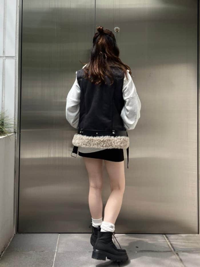 グレー系のスウェット、ブラック系のブーツ、ブラック系のスカートを着用したレディースの秋コーディネートの4枚目の写真