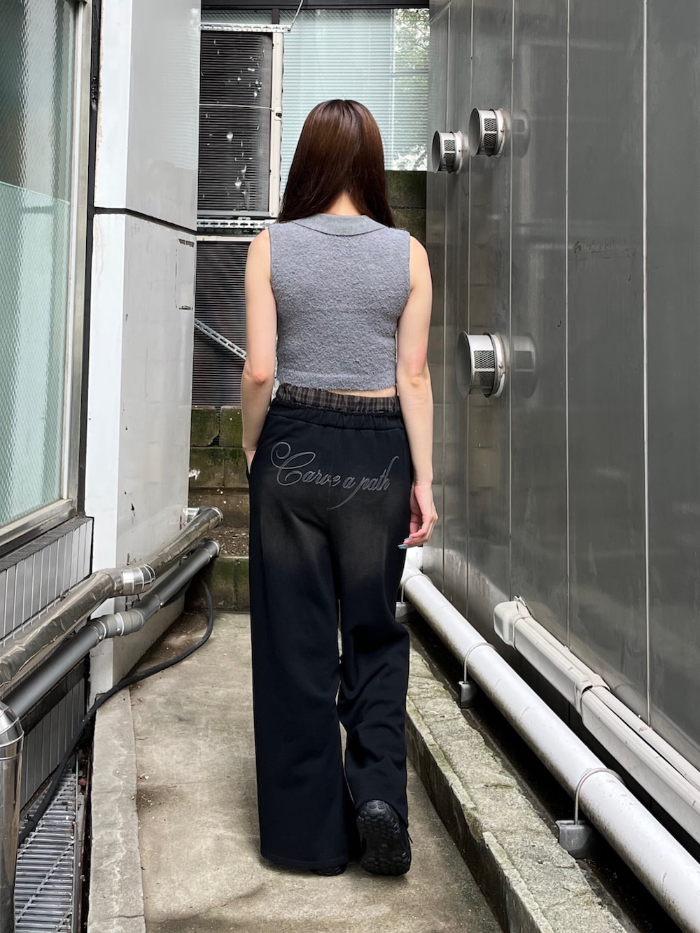 ブラック系のスニーカー、ブラック系のスウェットパンツ、グレー系のニット/セーターを着用したレディースの夏コーディネートの3枚目の写真