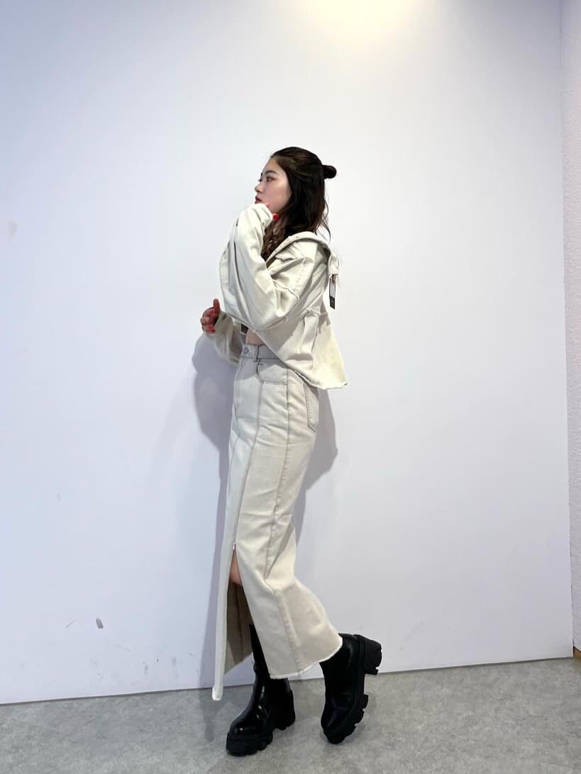 ホワイト系のデニムジャケット、ホワイト系のスカート、ブラック系のブーツを着用したレディースの夏コーディネートの3枚目の写真