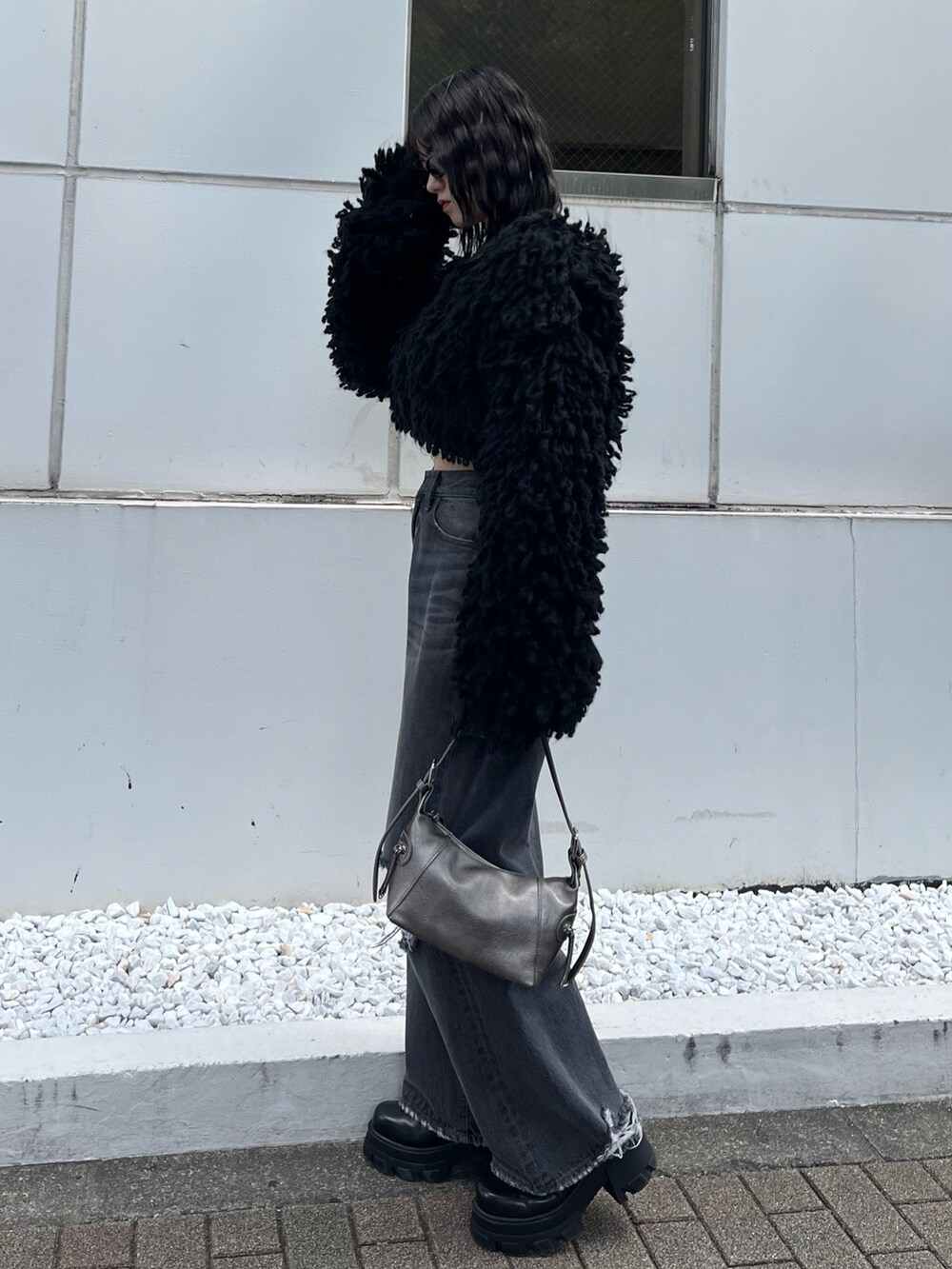 ブラック系のブーツ、グレー系のデニムパンツ、ブラック系のニット/セーターを着用したレディースの秋コーディネートの3枚目の写真