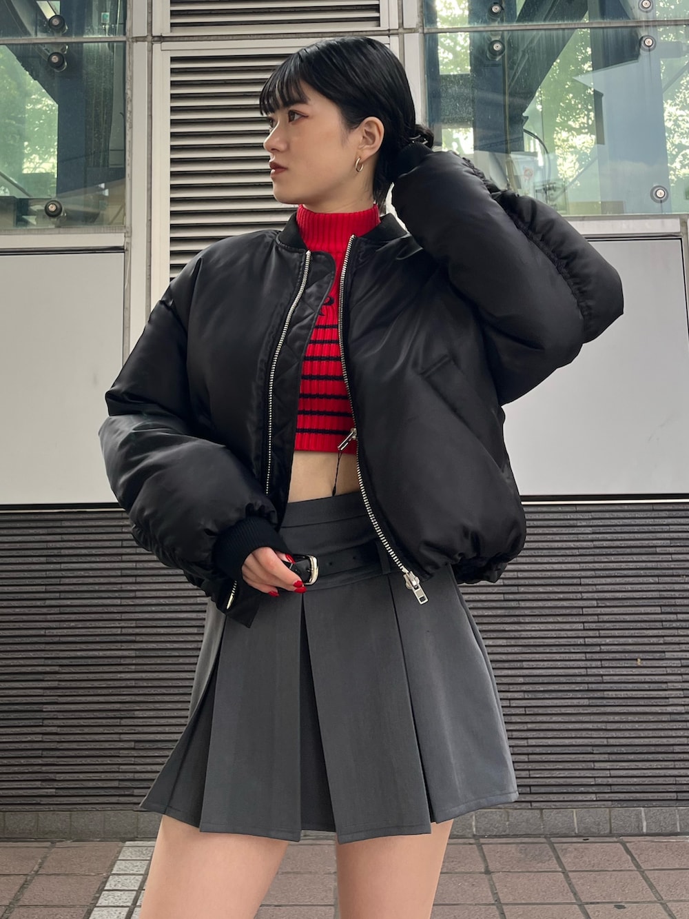 グレー系のスカート、レッド系のニット/セーター、ブラック系のブーツを着用したレディースの秋コーディネートの6枚目の写真