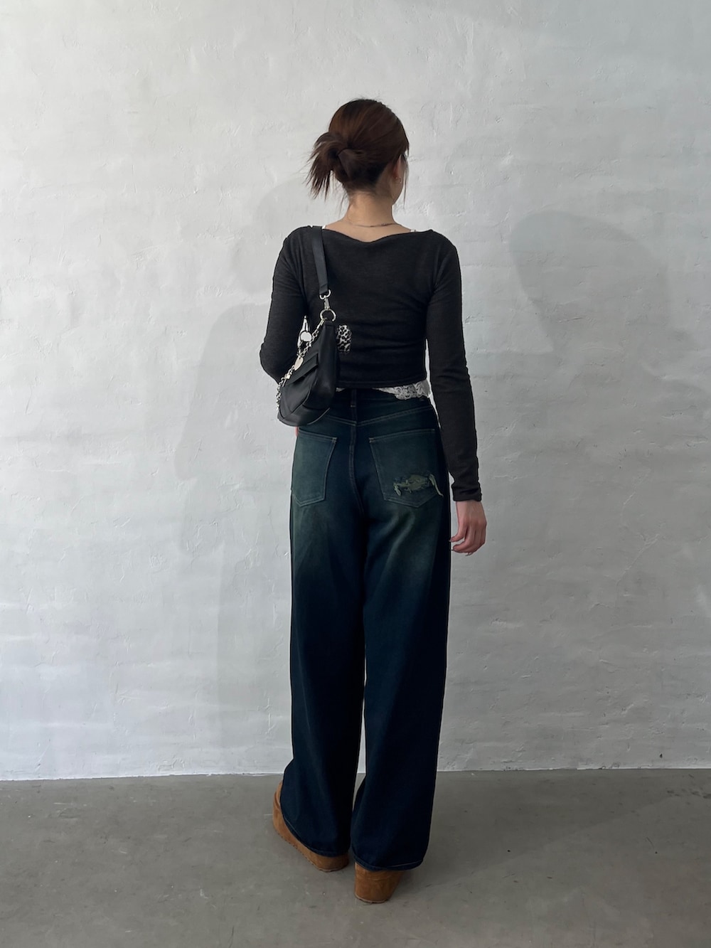 ブルー系のデニムパンツ、イエロー系のスリッポン、ブラック系のショルダーバッグを着用したレディースの秋コーディネートの3枚目の写真