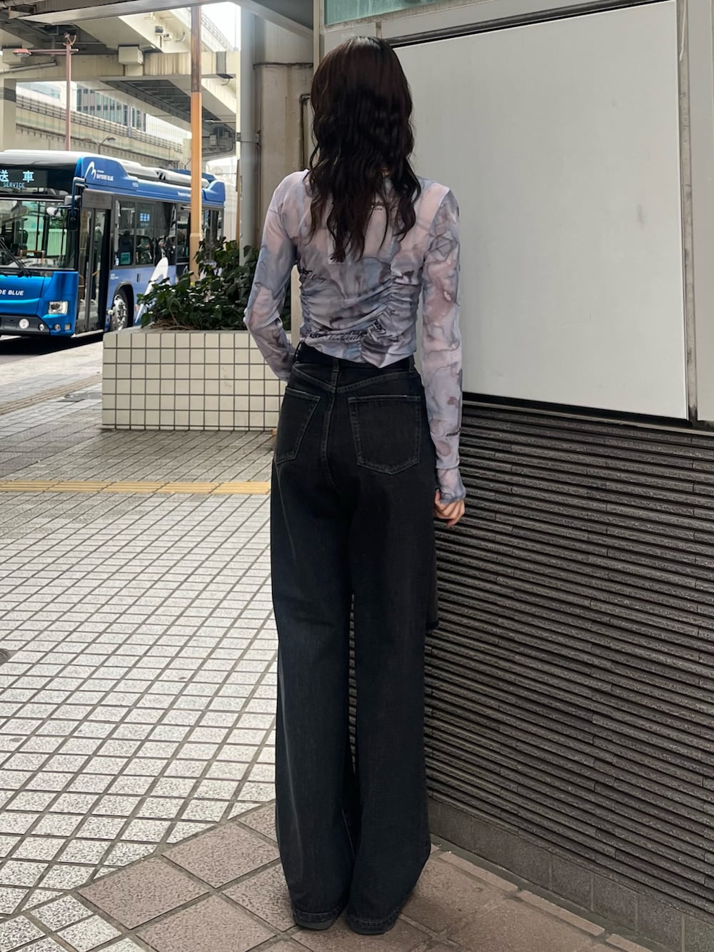 ブラック系のデニムパンツ、ブルー系のTシャツ/カットソー、ブラック系のブーツを着用したレディースの春コーディネートの4枚目の写真