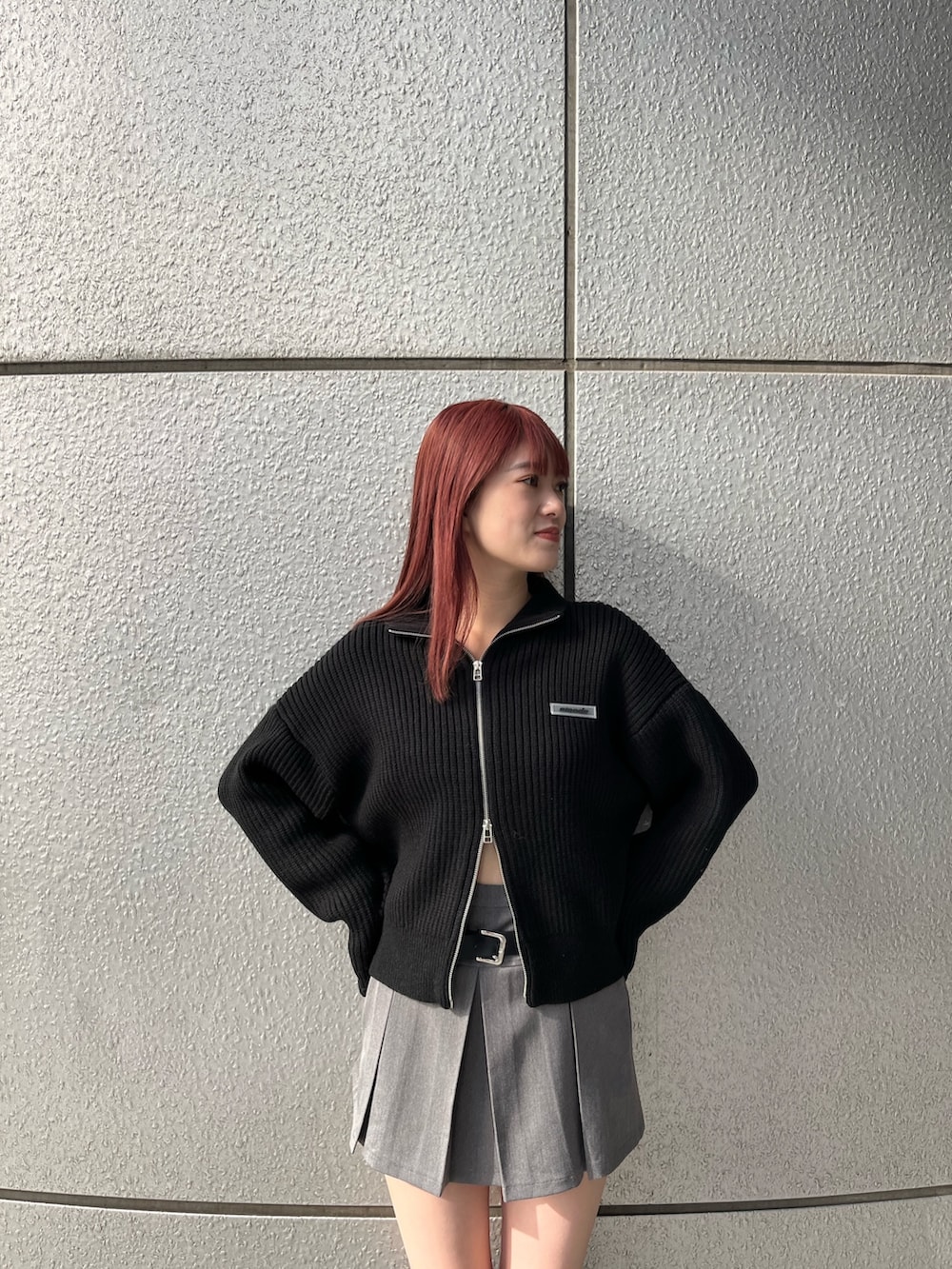 グレー系のスカート、ブラック系のブーツ、ブラック系のニット/セーターを着用したレディースの秋コーディネートの5枚目の写真