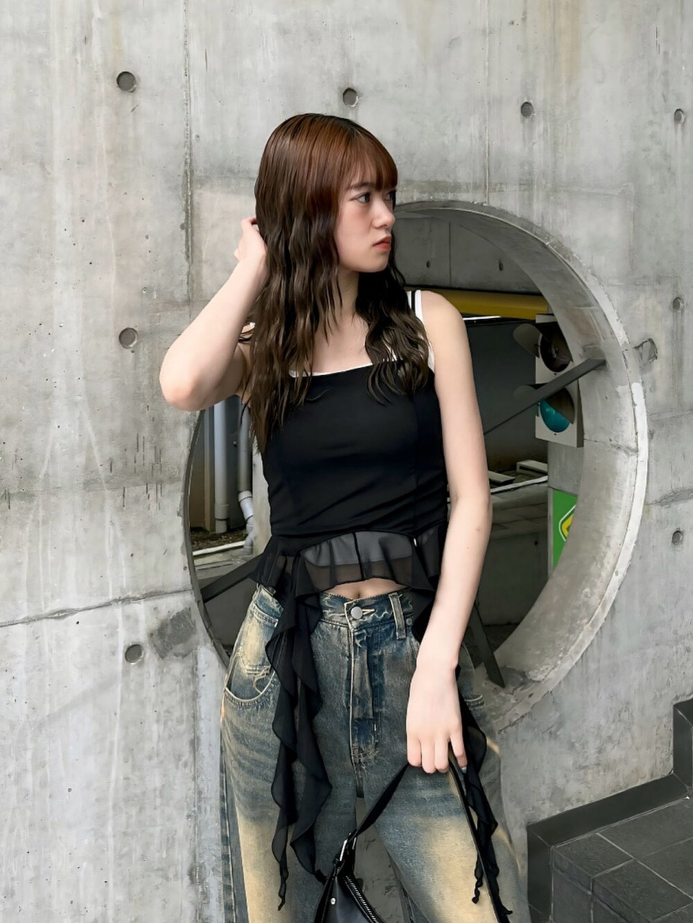 ブラック系のパンプス、ブラック系のTシャツ/カットソー、ブルー系のデニムパンツを着用したレディースの春コーディネートの4枚目の写真