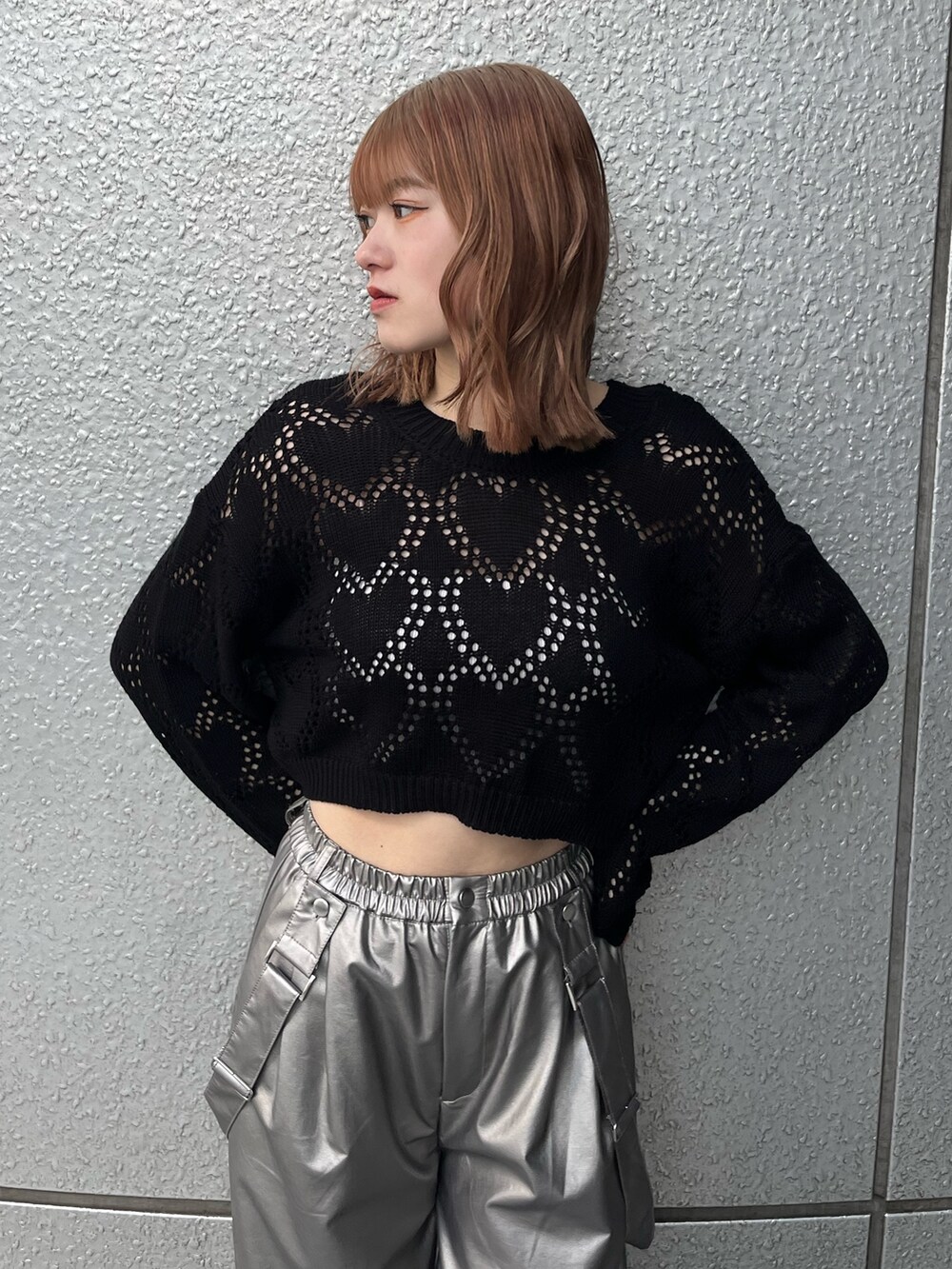 ブラック系のスニーカー、ブラック系のニット/セーター、ホワイト系のキャミソールを着用したレディースの冬コーディネートの4枚目の写真