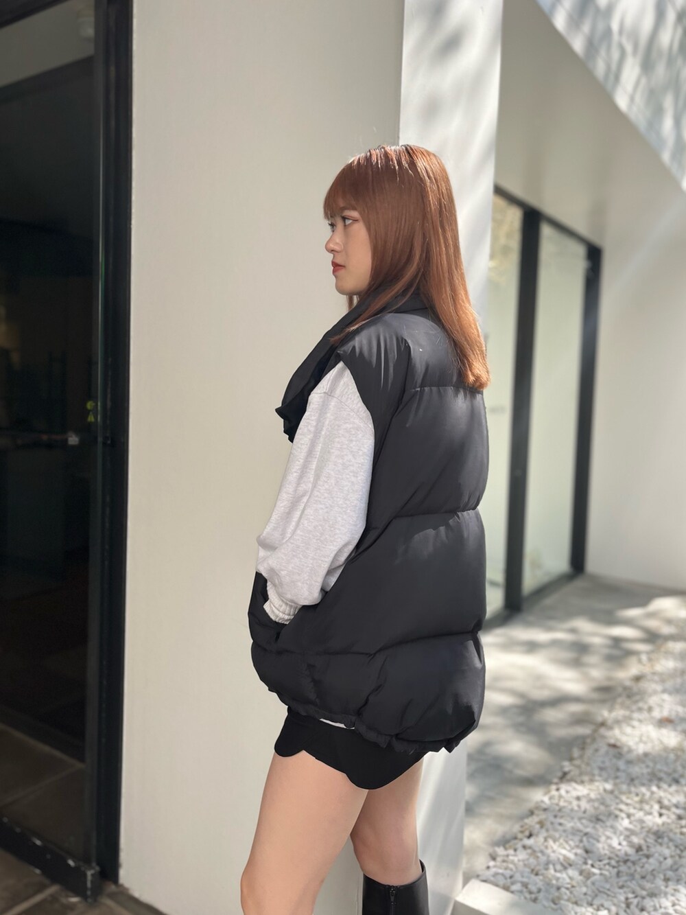 ブラック系のブーツ、グレー系のスウェット、ブラック系のスカートを着用したレディースの秋コーディネートの5枚目の写真