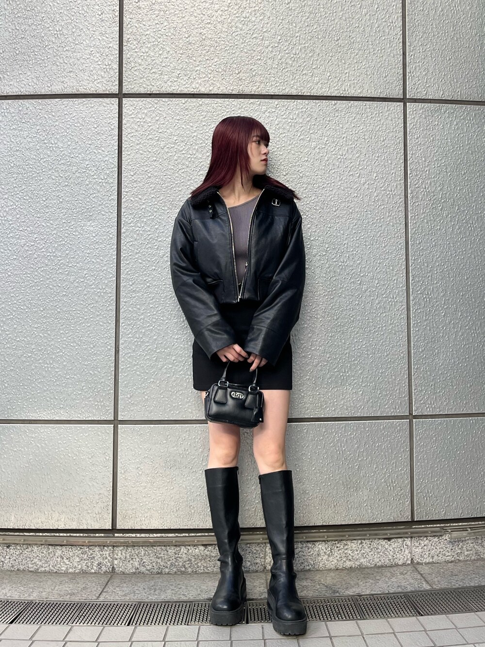 ブラック系のスカート、ブラック系のブルゾン、グレー系のニット/セーターを着用したレディースの冬コーディネートの2枚目の写真