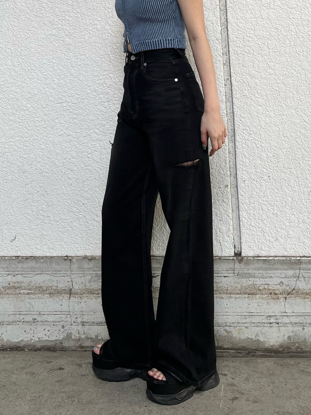 ブラック系のデニムパンツ、ブルー系のニット/セーター、ブラック系のサンダルを着用したレディースの夏コーディネートの6枚目の写真