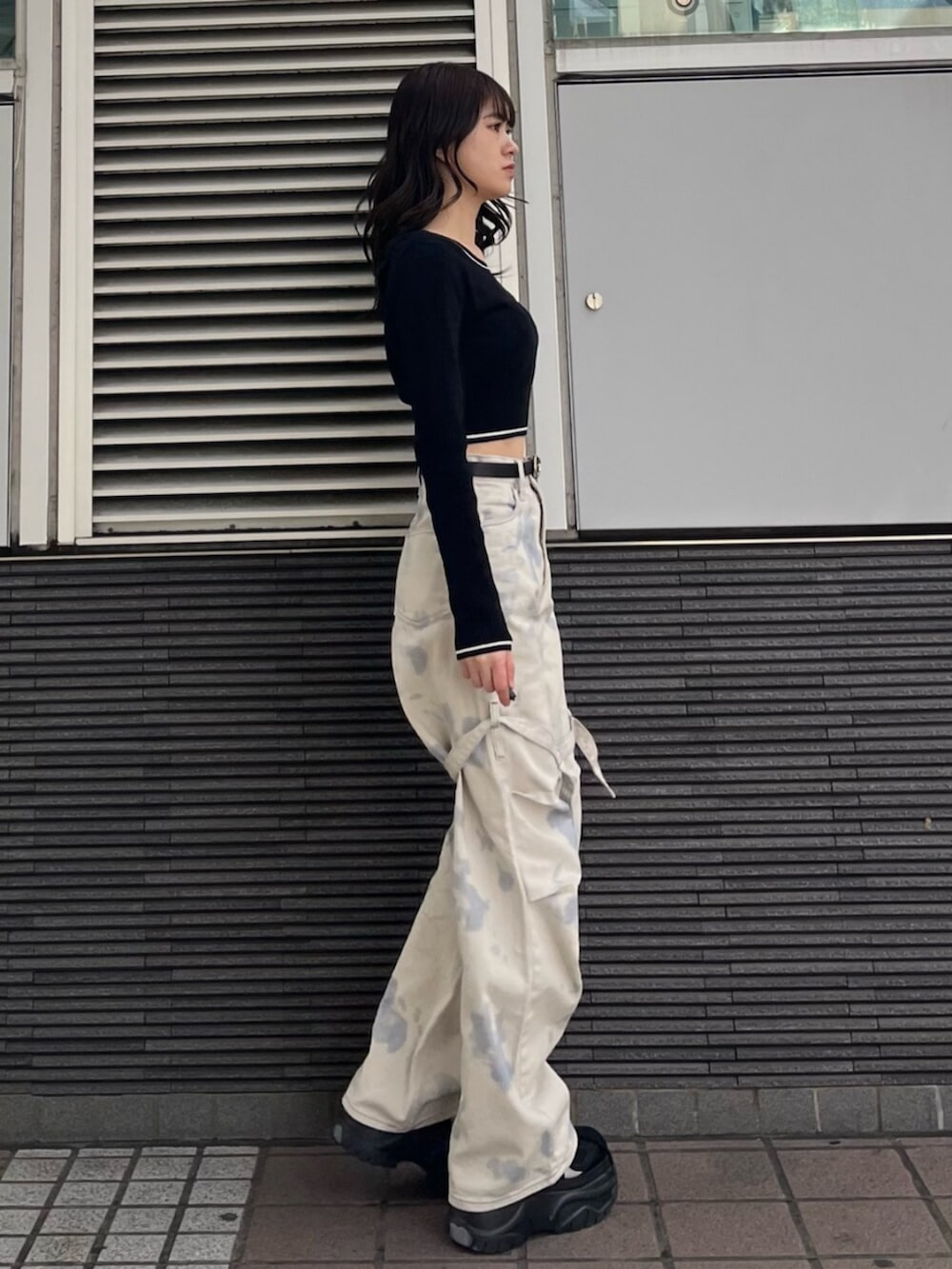 ブラック系のスニーカー、ホワイト系のデニムパンツ、ブラック系のニット/セーターを着用したレディースの冬コーディネートの5枚目の写真