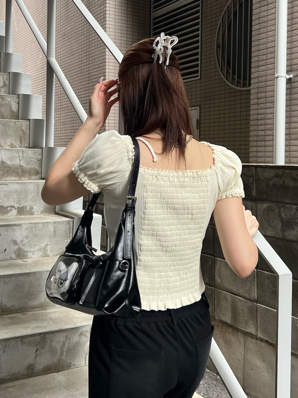 ホワイト系のTシャツ/カットソー、ブラック系のスウェットパンツ、ブラック系のハンドバッグを着用したレディースの夏コーディネートの6枚目の写真