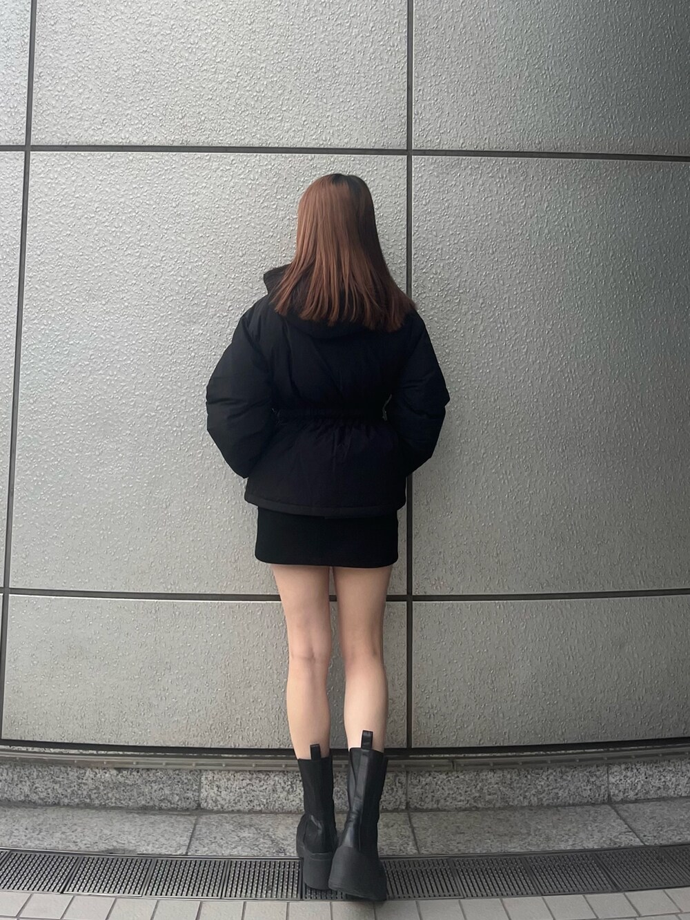 ブラック系のスカート、ブラック系のブーツ、ブラック系のブルゾンを着用したレディースの秋コーディネートの4枚目の写真