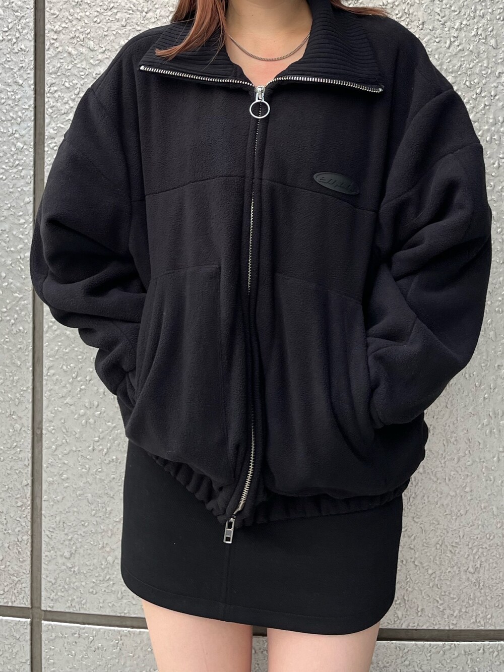 ブラック系のスカート、ブラック系のブーツ、ブラック系のブルゾンを着用したレディースの秋コーディネートの7枚目の写真