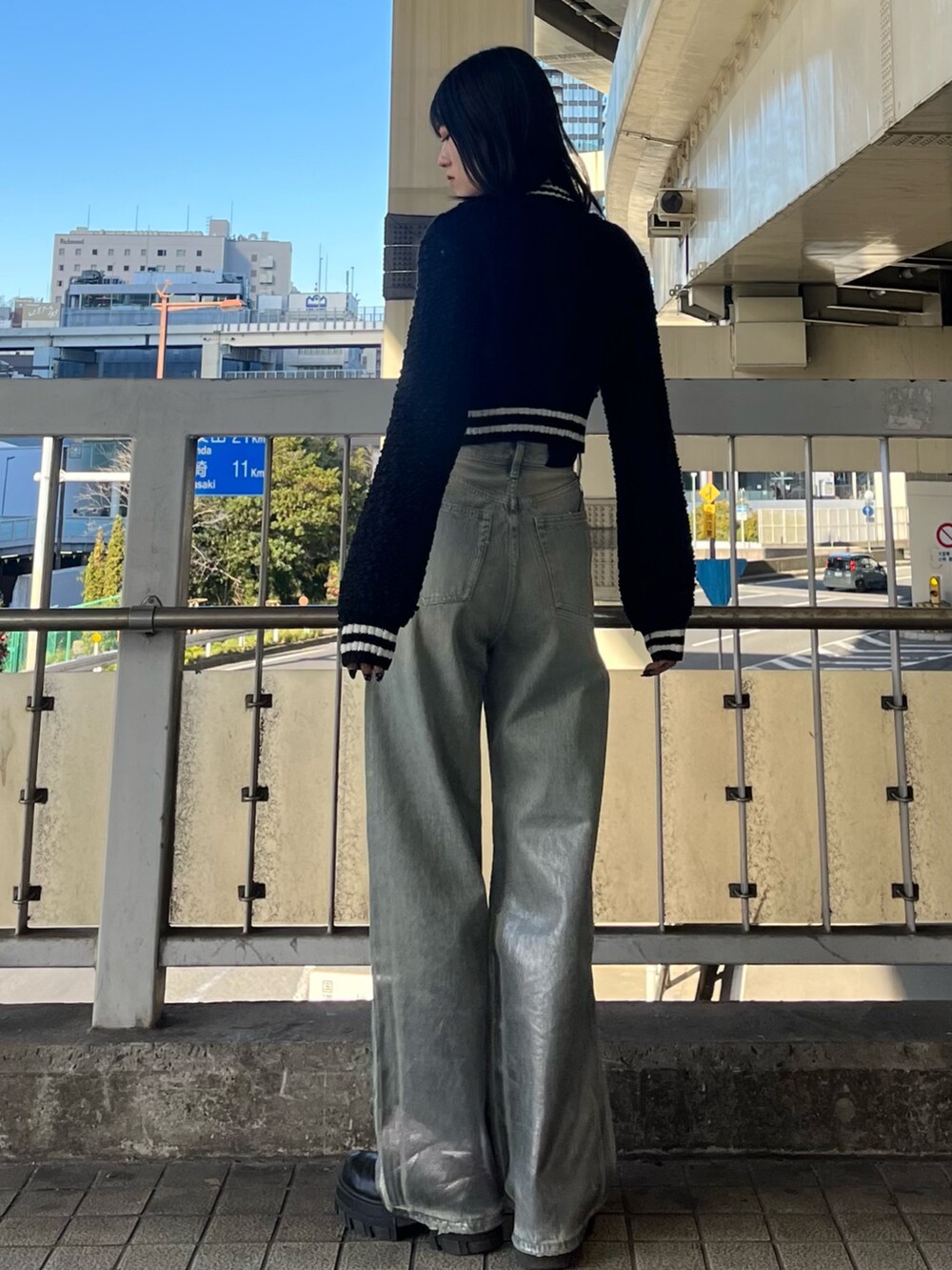 ブルー系のデニムパンツ、ブラック系のブーツ、ブラック系のカーディガン/ボレロを着用したレディースの冬コーディネートの3枚目の写真