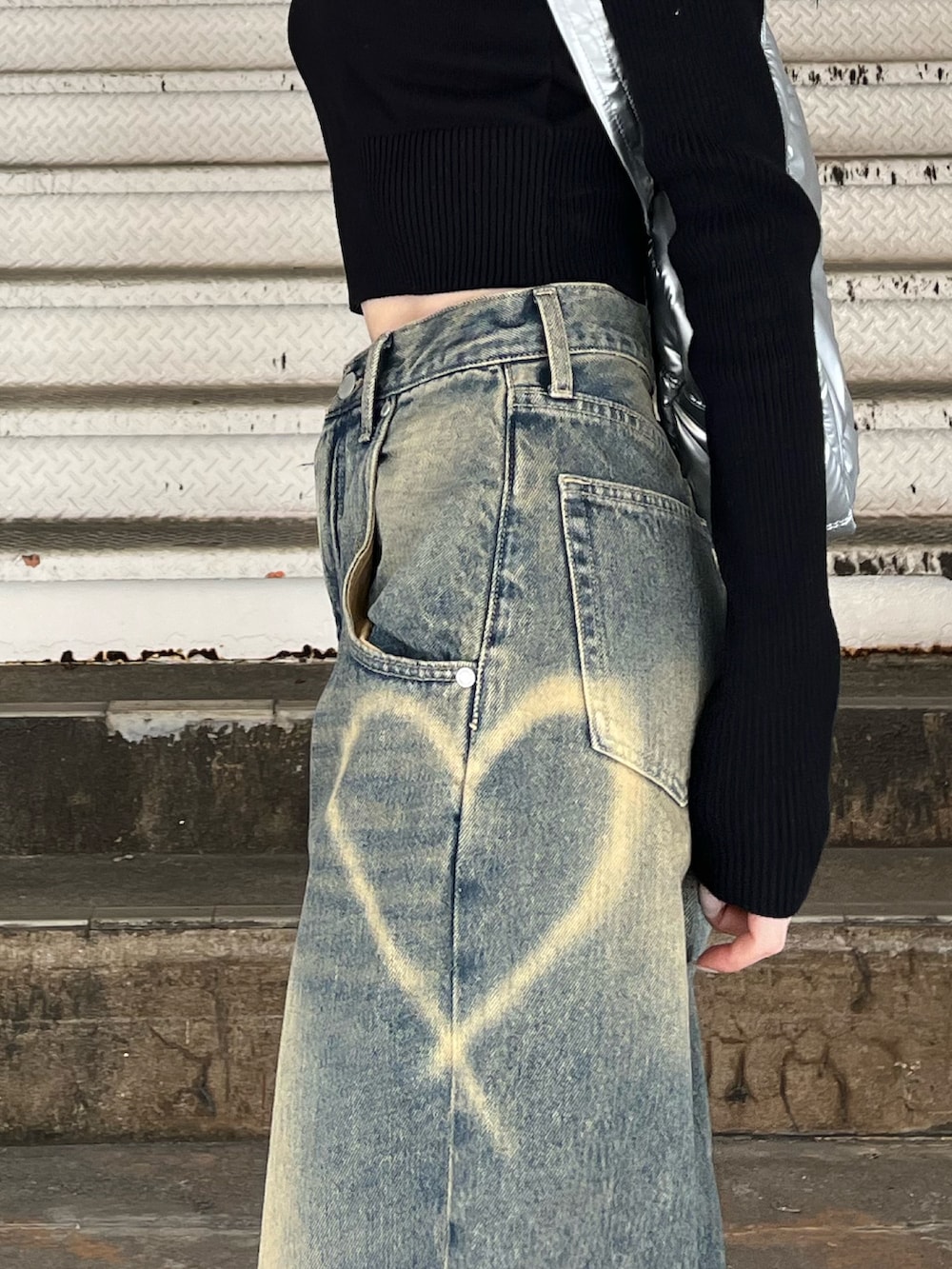 シルバー系のボストンバッグ、ブルー系のデニムパンツ、ブラック系のニット/セーターを着用したレディースの冬コーディネートの6枚目の写真