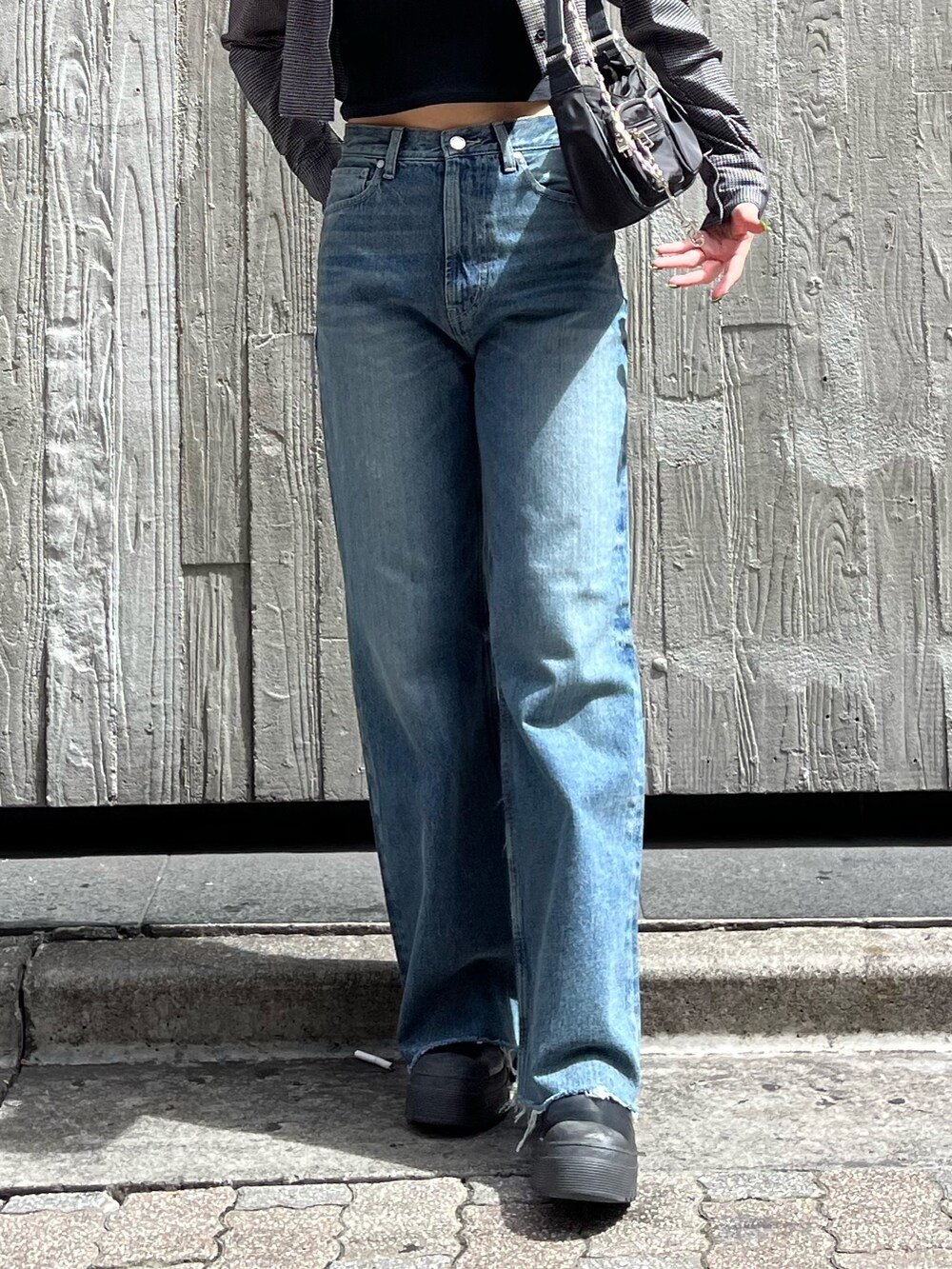 ブラック系のブーツ、ブラック系のキャミソール、ブルー系のデニムパンツを着用したレディースの夏コーディネートの6枚目の写真